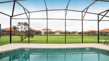 A swimming pool with a view of houses and a grassy area.