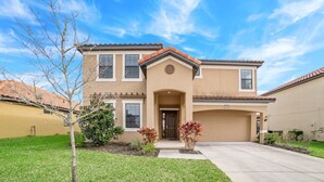 A two-story house with a front entrance, a garage, and a well-maintained lawn. - 2586rose (Davenport)