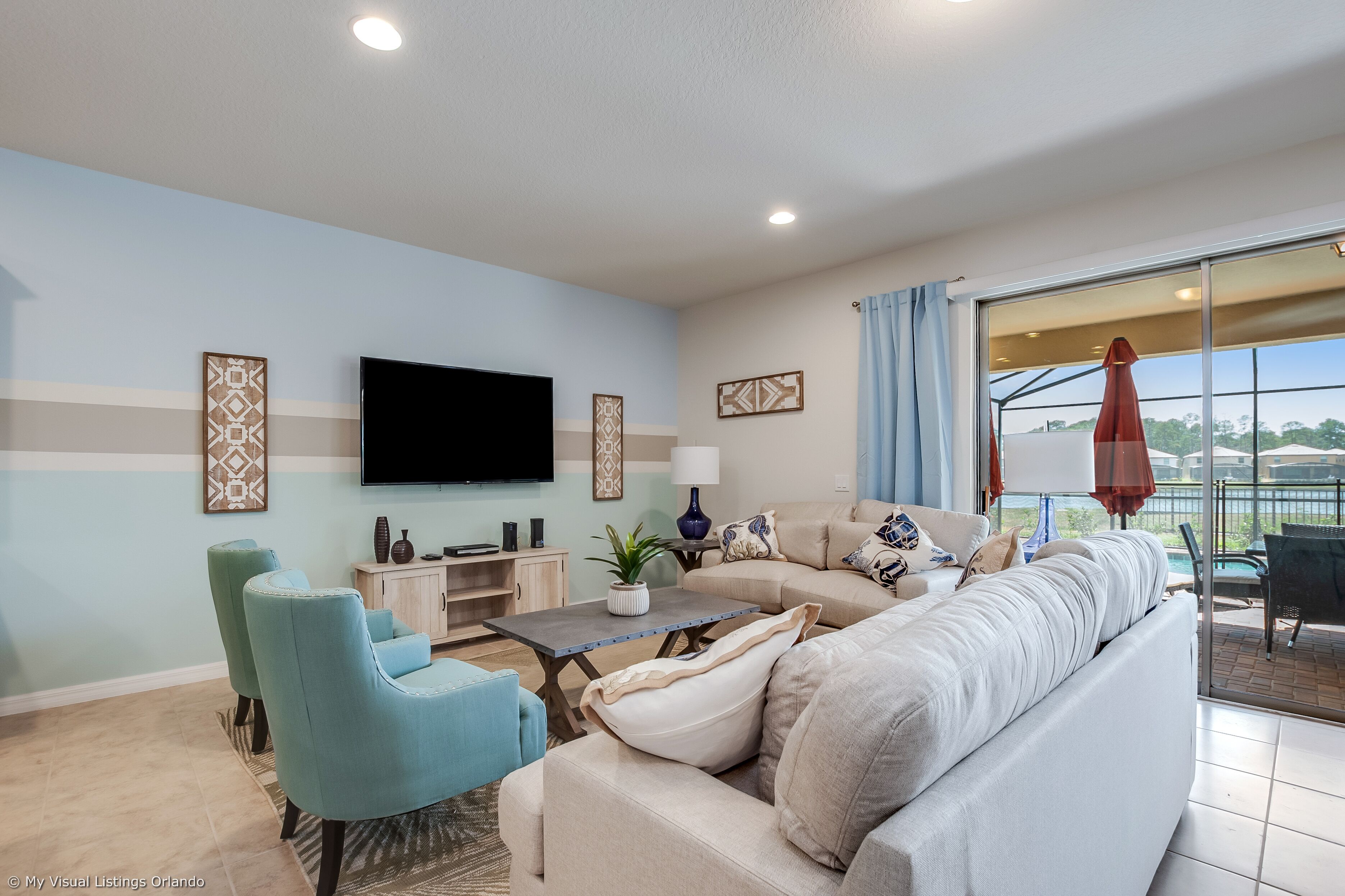 A living room with a sofa, chairs, a TV, and a table.