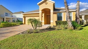 A residential building with a central entrance, a garage, and a well-maintained lawn with palm trees. - 2142victoria (Davenport)