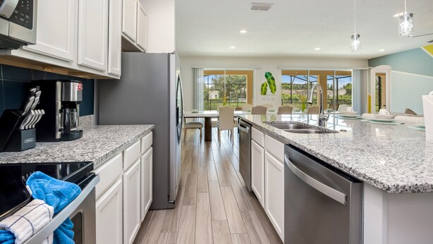 A modern kitchen with granite countertops, stainless steel appliances, and a view of the outdoors.