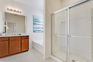 A modern bathroom with a glass shower enclosure, a bathtub, and a vanity with a mirror. - 7 Bed 5 Ba Villa with Games, Pool & Spa (Davenport)