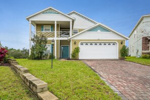 A two-story house with a front garage, a covered porch, and a brick driveway. - 2251victo (Davenport)