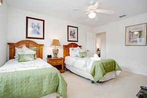 A bedroom with two beds, a ceiling fan, and framed artwork on the walls. - 2131victoria (Davenport)