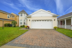 A residential house with a garage, a brick driveway, and a well-maintained lawn. - 2131victoria (Davenport)