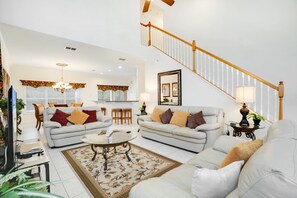A spacious living room with two sofas, a coffee table, and a staircase leading to an upper level. - 2131victoria (Davenport)