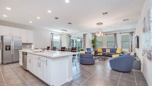 A modern kitchen with white cabinets, a stainless steel refrigerator, and a central island.