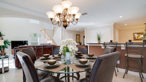 A dining area with a glass table, brown leather chairs, and a chandelier. - 2173victoria (Davenport)