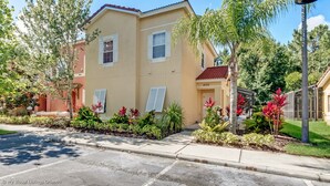 A two-story residential building with a beige facade, white shutters, and a red roof. - 4732tvero (Kissimmee)