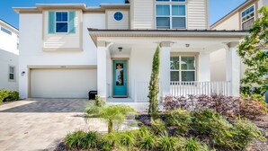 A two-story house with a garage, a front porch, and a well-maintained garden.