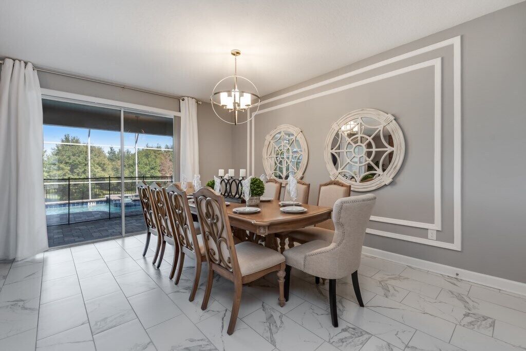 A dining room with a large table, chairs, and decorative wall art.