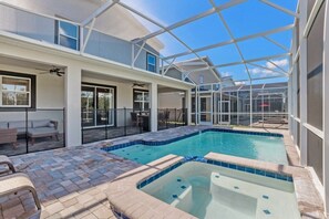 A modern house with a glass-enclosed patio, a swimming pool, and outdoor furniture. - 8 Bed 5 Ba Villa with Games, Pool & Spa (Davenport)