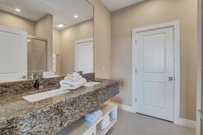 A modern bathroom with a granite countertop, two sinks, a large mirror, and a white door. - Modern Magic Village Resort Townhouse 7620 (Kissimmee)