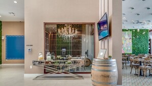 A restaurant interior with a modern design, featuring a chandelier, a large wooden barrel, and a television mounted on the wall. - 7605reclife (Kissimmee)