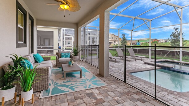 A covered patio with a pool, outdoor seating, and large windows.
