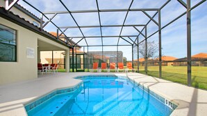 A swimming pool with a glass enclosure, surrounded by lounge chairs and a covered patio area. - 2590rose (Davenport)