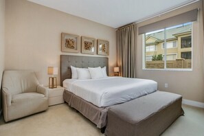 A hotel room with a large bed, a chair, a nightstand, and a window with a view of buildings. - 7577brooklin (Kissimmee)