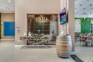 A restaurant with a modern interior, featuring a chandelier, a large wooden barrel, and a television mounted on the wall. - 7577brooklin (Kissimmee)