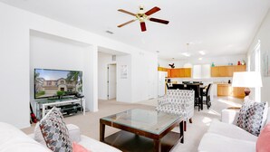 A modern living room with a glass coffee table, white sofas, and a ceiling fan. - 436alderidge (Davenport)