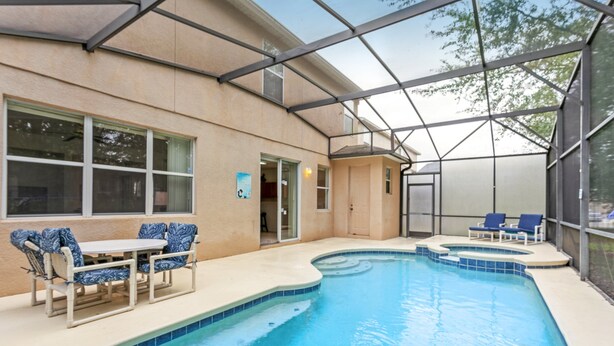 A swimming pool with a covered patio area, including seating and a door leading to an interior space. - 436alderidge (Davenport)