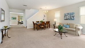 A spacious living room with a dining area, a staircase, and a sofa. - 436alderidge (Davenport)