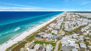 A coastal residential area with houses, a beach, and a clear blue sky. - Sandpiper Cottage - Four Bedroom Close to Pool & Beach (Rosemary Beach)