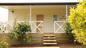 A house with a porch, a wooden fence, and a small staircase leading to the door. - Bridgecroft Villa (Richmond)