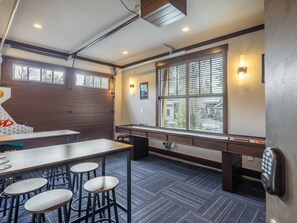 A modern kitchen with a long counter, bar stools, and a window with blinds. - Game Room, Private Hot Tub & Suncadia Pool Access (Cle Elum)
