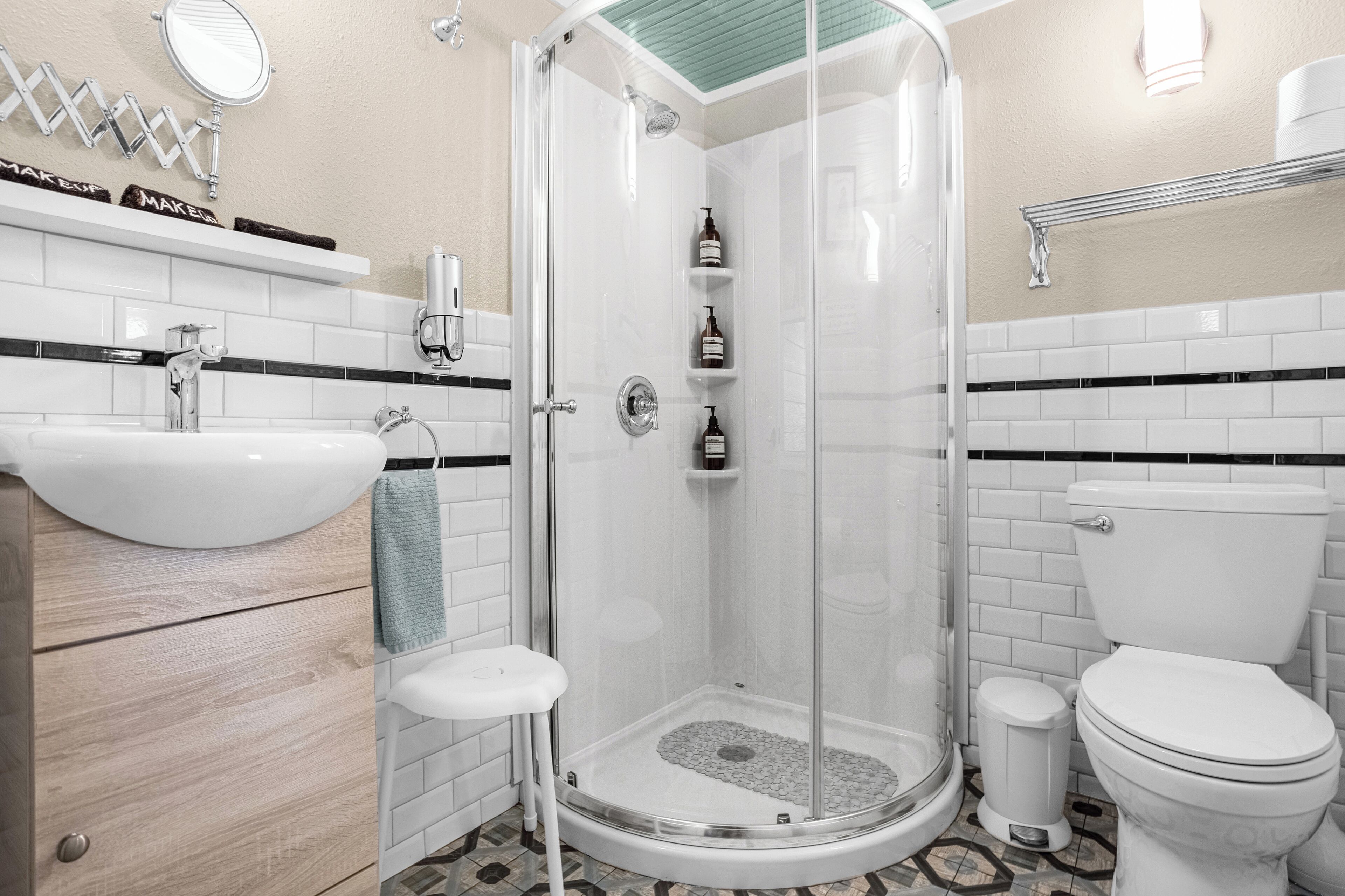 Un bagno moderno con cabina doccia in vetro, lavabo bianco e water.