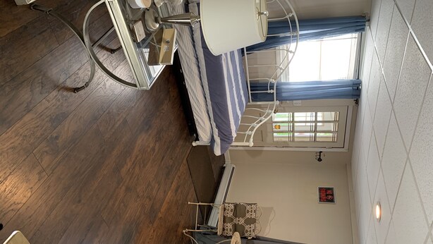 A high ceiling with a fan, a bed with a striped pillow, and a window with curtains. - 1 bedroom apt.Minutes to Encore Casino and Boston. (Revere)