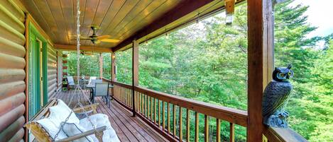 A wooden deck with a hanging chair and a statue of an owl.