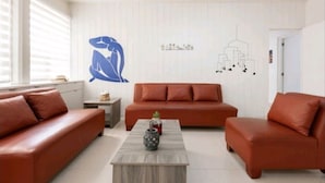 A living room with a brown sofa set, a coffee table, and wall art.