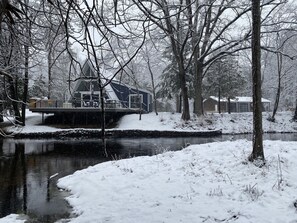 Relax on the houseboat's balcony, surrounded by snow-covered trees and tranquil waters.
