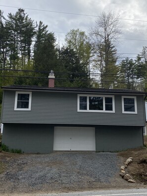 A single-story building with a garage, a chimney, and a row of windows. - Adirondack Escape on the Great Sacandaga Lake (Hadley)
