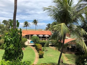 Un resort con piscina, palmeras y un edificio de techo rojo.
