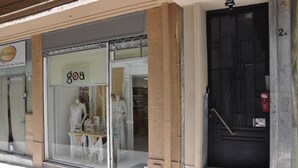 Un escaparate con fachada de vidrio, maniquíes y un letrero que dice "goa".