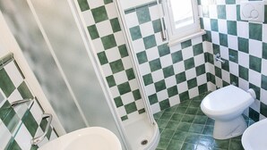 A bathroom with a shower, two toilets, and a sink. - M030 - Marcelli, new two-room apartment facing the sea (Marcelli)