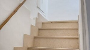 Una scala con gradini color beige e una ringhiera in legno.
