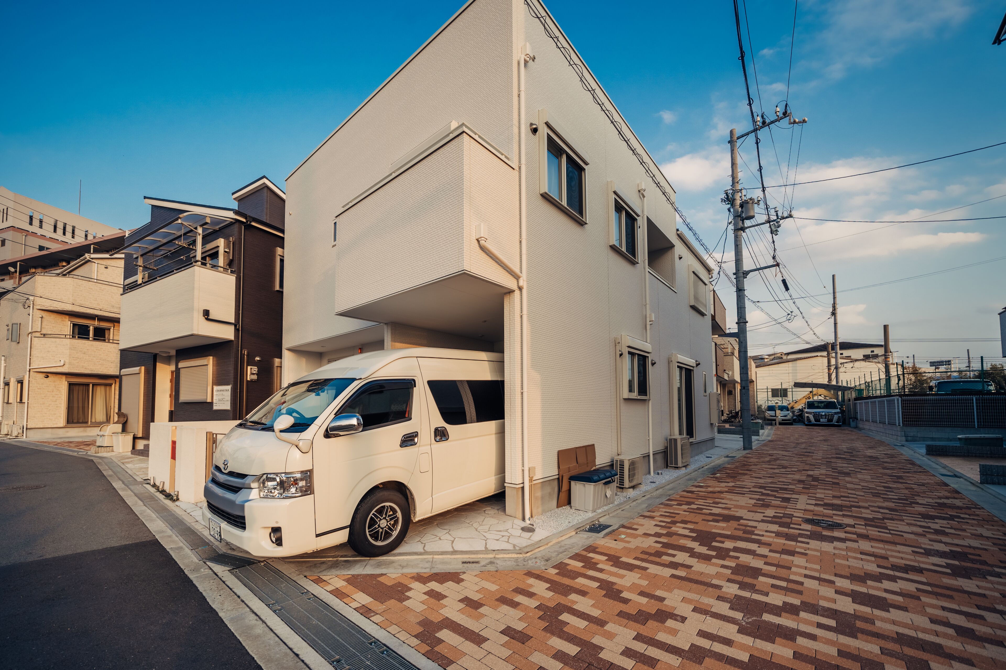 A modern two-story building with a white van parked in front.