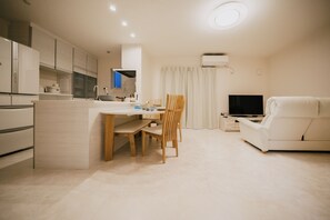 Eine moderne Küche mit Essbereich, einer Sitzecke und einem Fernseher.