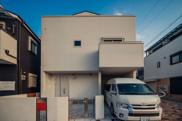 A modern building with a white exterior, a garage, and a parked van.
