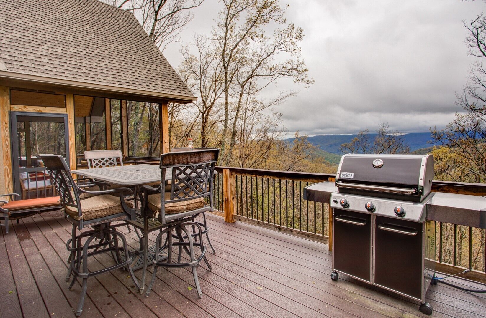 Une terrasse extérieure équipée d’un barbecue, d’une table à manger et de chaises.