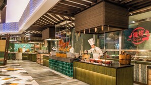 A restaurant with a chef preparing food, a buffet counter, and a tiled floor. - Grand Lisboa Palace Macau (Cotai)