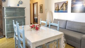 Zona pranzo con tavolo, sedie e divano.