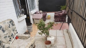 A small outdoor seating area with a sofa, a chair, and a potted plant. - Family atmosphere 20 (Viña)