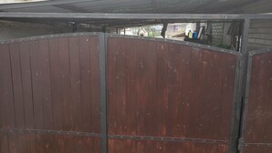 A wooden gate with metal reinforcements, leading to a covered area with a roof. - Family atmosphere 20 (Viña)