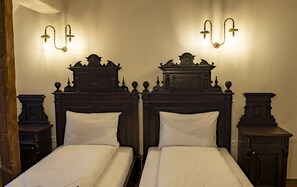 Een tweepersoonsbed met een houten hoofdbord en twee nachtkastjes.