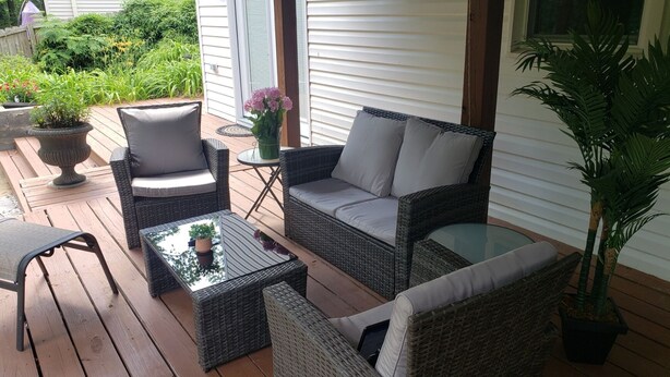 A covered patio with wicker furniture, a glass table, and potted plants. - Spacious suite with private patio, minutes from DC / DCA (Arlington)
