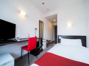 A hotel room with a bed, a desk with a chair, a television, and a mirror. - Super Hotel Inn Hakata (Fukuoka)