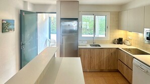 Een moderne keuken met een koelkast, spoelbak en vaatwasser.